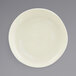 A Front of the House vanilla bean porcelain plate with a small rim on a gray surface.