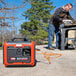 A man using a Simpson portable power generator to power a circular saw.