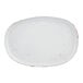 An oval white porcelain plate with a slightly rustic, worn finish.
