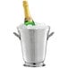 A Tablecraft stainless steel wine bucket filled with ice and a champagne bottle.