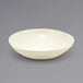 A Front of the House vanilla bean porcelain bowl on a gray surface.