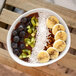 A white Front of the House porcelain bowl filled with fruit and nuts.