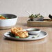 An Artefact porcelain plate with food on a table.