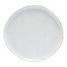 A round, white porcelain plate with subtle speckled detailing and a slightly rustic finish.
