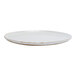 A round, white porcelain plate with a slightly rustic, worn edge.