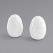 A pair of white egg-shaped porcelain salt and pepper shakers.