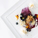 A Front of the House white square porcelain plate topped with dessert and berries.