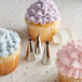 A close up of a cupcake with purple ruffle frosting made using Ateco ruffle piping tips.