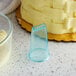 A close up of a plastic container with white cream and a blue plastic cup next to a bowl of cake decorated with basketweave frosting.