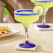 Two Acopa Tropic margarita glasses with margaritas garnished with lime slices.