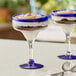 A close-up of two Acopa Tropic margarita glasses with dessert in them.