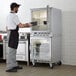 A man standing in a kitchen with a Beverage-Air undercounter freezer.