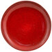 A close up of a red kiln porcelain plate with black specks.