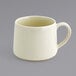 A close-up of a Front of the House vanilla bean porcelain cup with a white handle.