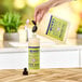 A hand pouring Mrs. Meyer's Lemon Verbena soap into a container.