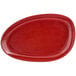 A white porcelain oval plate with red chili designs on the rim and center.