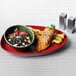 A Front of the House porcelain oval plate with a bowl of chili and rice.