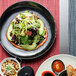 A plate of salad with avocado and vegetables on a Kiln Porcelain Plate.