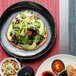 A plate of food with salad, avocado, and vegetables on a table.