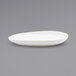 A close up of a white Front of the House oval plate on a gray surface.
