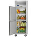 A Traulsen G Series reach-in refrigerator with left hinged doors full of groceries.
