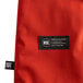 A close up of a red San Jamar Cool Touch oven mitt with a Kevlar web guard.