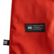 An orange San Jamar oven mitt with a red Kevlar web guard.