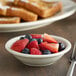 A white Acopa stoneware bowl with a fork and fruit.