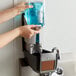 A person using a Rubbermaid Lumecel automatic soap dispenser.