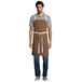Uncommon Threads 3104 Caramel 100% Cotton Rebel Bib Apron with Natural Webbing and 3 Pockets - 34 inchL x 36 inchW