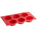 A red silicone brioche mold with six compartments.