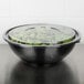 a bowl of salad on a black surface