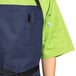 A person wearing a blue denim Uncommon Chef bib apron over a green shirt.