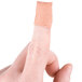 A close-up of a finger with a Medique woven fingertip bandage on it.