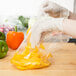 a hand in a plastic bag of yellow peppers