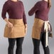 Two women wearing Uncommon Chef caramel waist aprons with natural webbing.
