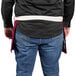 A man wearing a burgundy Uncommon Chef waist apron with natural webbing.