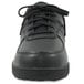 A close-up of a black Genuine Grip women's leather shoe with laces.