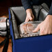 A man using Sterno Royal Blue insulated food carrier to hold plastic containers.