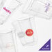 A close-up of a clear Fabri-Kal plastic cup with a pink logo.