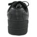 A close up of a Genuine Grip black leather shoe with laces and a rubber sole.