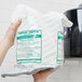 A person holding a plastic bag of Merfin Mates personal care wipes.