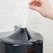 A hand pulling a Merfin Mates pre-moistened personal care wipe from a black plastic box.