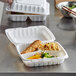 A white ProPlanet 3 compartment takeout container filled with food on a table.