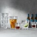 A group of Spiegelau Perfect Serve glasses filled with various drinks on a table.