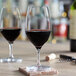A Spiegelau red wine glass filled with red wine on a table.