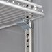 A metal shelf with a metal bracket attached to it inside a Beverage-Air Horizon Series glass door refrigerator.