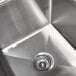 A stainless steel Advance Tabco two compartment sink with two drainboards and a center drain.