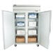 A Beverage-Air reach-in freezer with half glass doors open and shelves full of boxes.