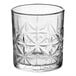 A clear glass with a decorative, textured pattern, designed for serving rocks or old fashioned drinks.